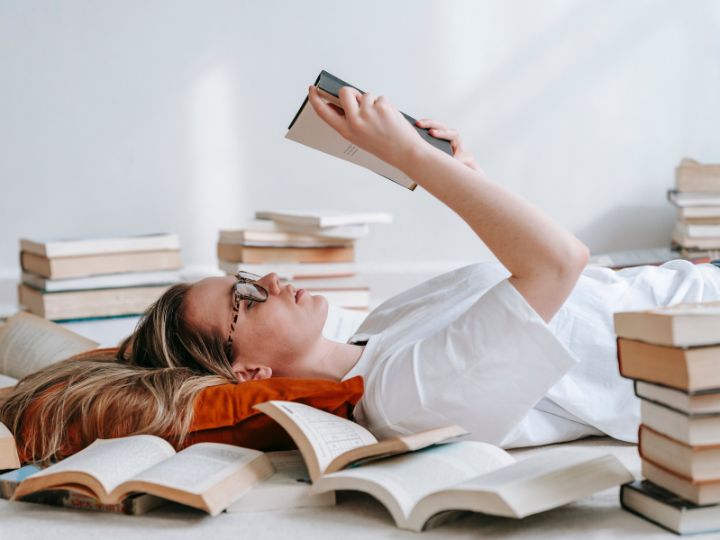 Seorang anak yang sedang bersantai membaca buku